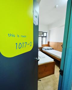 een kamer met een deur met een bord waarop staat dat dit kamer is bij Ah Shan Hostel in Hong Kong