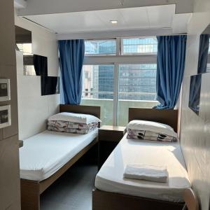 twee bedden in een kamer met een raam bij Ah Shan Hostel in Hong Kong