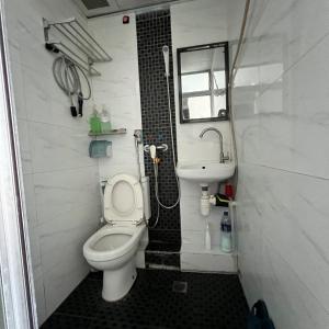 a small bathroom with a toilet and a sink at Ah Shan Hostel in Hong Kong