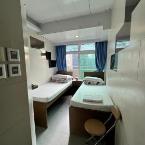 Habitación pequeña con 2 camas y ventana en Ah Shan Hostel, en Hong Kong
