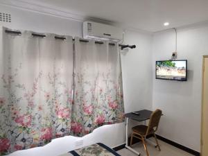 MATT Bed and Breakfast في ليلونغوي: غرفة بها سرير وتلفزيون على الحائط
