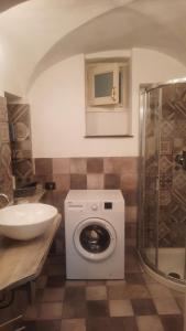 een badkamer met een wasmachine en een wastafel bij ''SAPORE DI PROVENZA'' Sole Mare Quiete in Terzorio