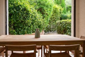 een houten tafel met stoelen en een vaas erop bij Superbe 3 pièces dans Saint Tropez avec piscine et terrasse in Saint-Tropez