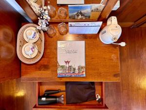 una mesa con una botella de vino y otros artículos. en Dinsomon Hotel, en Bangkok