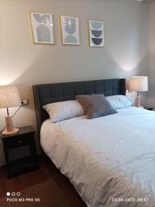 um quarto com uma cama com 2 candeeiros e fotografias na parede em Apartamento Piscina 2G by Urraca Suites Viveiro em Viveiro