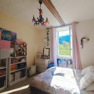 a bedroom with a bed and a window at Chambres d'hôtes dans Mas avec jardin en bord de rivière in Saumane
