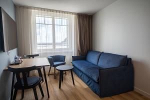 a living room with a blue couch and a table at Hôtel de la Baie in Crozon