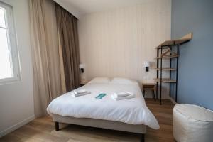 a hotel room with a bed and a chair at Hôtel de la Baie in Crozon