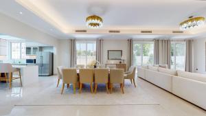 a dining room and living room with a table and chairs at Primestay - Flame Tree Ridge 4BR Villa with Private Pool in Dubai