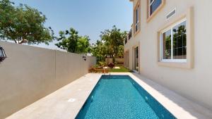 a swimming pool in the backyard of a house at Primestay - Flame Tree Ridge 4BR Villa with Private Pool in Dubai