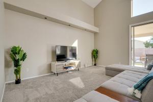 a living room with a couch and a tv at Phoenix Home with Private Pool, 16 Mi to Downtown! in Phoenix