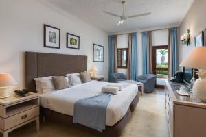 a bedroom with a bed and a desk and a television at Hotel Ta' Cenc & Spa in Sannat