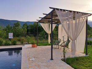 a patio with a canopy and a swimming pool at Villa Vinka in Kozica