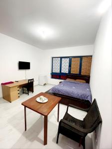 Schlafzimmer mit einem Bett, einem Tisch und einem Schreibtisch in der Unterkunft Abu Dhabi Centre - Unique Room in Abu Dhabi