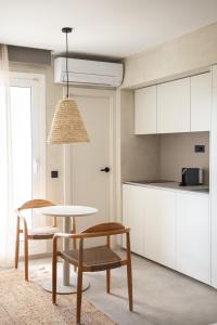 a kitchen with white cabinets and a table and chairs at Apartamentos Top Secret Es Pujols - Formentera Vacaciones in Es Pujols