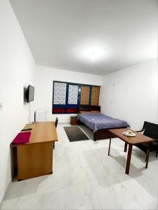 Schlafzimmer mit einem Bett, einem Schreibtisch und einem Tisch in der Unterkunft Abu Dhabi Centre - Unique Room in Abu Dhabi