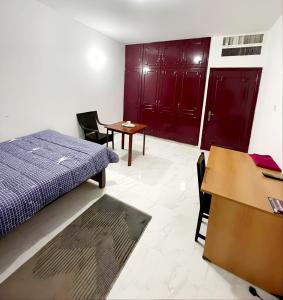 Schlafzimmer mit einem Bett, einem Schreibtisch und einem Tisch in der Unterkunft Abu Dhabi Centre - Unique Room in Abu Dhabi