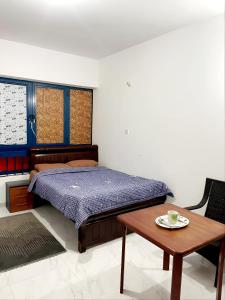 Schlafzimmer mit einem Bett und einem Holztisch in der Unterkunft Abu Dhabi Centre - Unique Room in Abu Dhabi