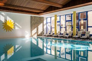 a large swimming pool with chairs and a pool at Abitaziun Europa 302 - Champfèr in Champfer