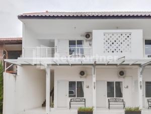 a white house with two benches on the porch at Khayrizsan Guest House Mitra RedDoorz in Cibeureum +5 photos