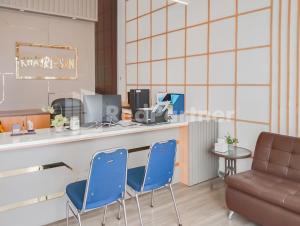 a waiting room with two blue chairs and a counter at Khayrizsan Guest House Mitra RedDoorz 