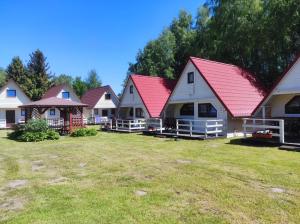 a row of houses with red roofs on a yard at Domki Letniskowe Bryza in Jarosławiec