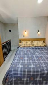 ein Schlafzimmer mit einem blauen Bett mit zwei Kissen in der Unterkunft Beji Loft in Dalung