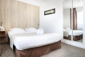 a hotel room with two beds and a mirror at Hôtel La Petite Sirène Quiberon in Quiberon
