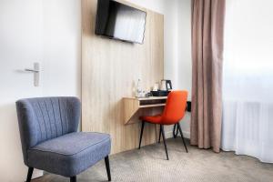 a room with a chair and a desk with a television at Hôtel La Petite Sirène Quiberon in Quiberon