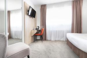 a hotel room with a bed and a chair and a desk at Hôtel La Petite Sirène Quiberon in Quiberon