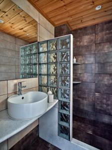 a bathroom with a sink and glass wine racks at Hotel Galini in Naousa
