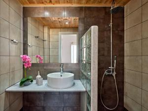 uma casa de banho com um lavatório e um chuveiro em Hotel Galini em Naousa