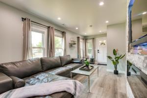 a living room with a leather couch and a table at Des Plaines Vacation Rental with Spacious Backyard! in Des Plaines
