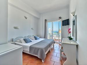 una camera bianca con letto e balcone di Hotel Galini a Naoussa
