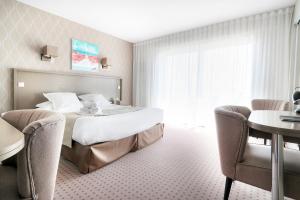 a hotel room with a bed and a table and chairs at Hôtel La Petite Sirène Quiberon in Quiberon