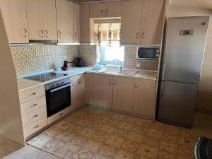 a kitchen with wooden cabinets and a refrigerator at Urban House Koukouroumas in Sykia Chalkidikis