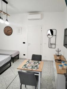 a room with a table and chairs and a bed at Petracca Guest House in Monopoli