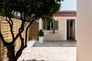 a patio with a table and chairs in front of a house at ALS Holiday Houses by Konnect, 900m from Ipsos Beach in Ýpsos