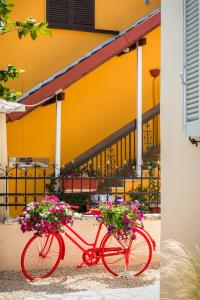 a red bike with two baskets filled with flowers at ALS Holiday Houses by Konnect, 900m from Ipsos Beach in Ýpsos