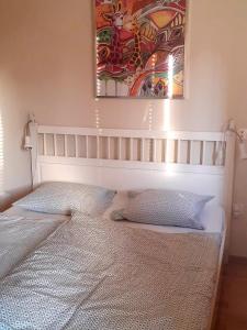 sypialnia z łóżkiem z obrazem na ścianie w obiekcie Rita apartman w Siófoku