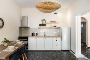 a kitchen with a white refrigerator and a table at ALS Holiday Houses by Konnect, 900m from Ipsos Beach in Ipsos