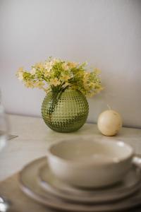 a vase with flowers and a egg on a table at ALS Holiday Houses by Konnect, 900m from Ipsos Beach in Ýpsos