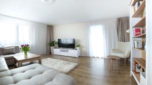a living room with a white couch and a tv at PerfectSpa Apartment in Humenné