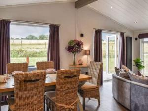 a dining room with a table and chairs at Gorstage Meadows Luxury 2 Bedroom Lodge in Rural Cheshire in Hartford