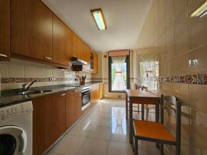 a kitchen with wooden cabinets and a table and a dishwasher at R2R - El Mirador de Llaneces - 24A02 in Arenas de Cabrales