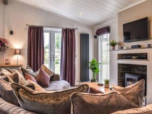 un soggiorno con divano e camino di Gorstage Meadows Luxury 2 Bedroom Lodge in Rural Cheshire a Hartford