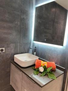 a bathroom with a sink and flowers on a counter at Beach side Duplex in Punaauia