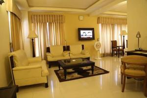 拉希姆亞爾汗的住宿－Royal Desert Palm Hotel，客厅配有沙发、椅子和桌子