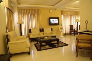 a living room with a couch and chairs and a table at Royal Desert Palm Hotel in Rahimyar Khan