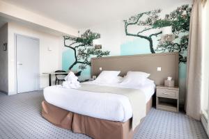a bedroom with two beds and a wall with trees at Hôtel La Petite Sirène Quiberon in Quiberon